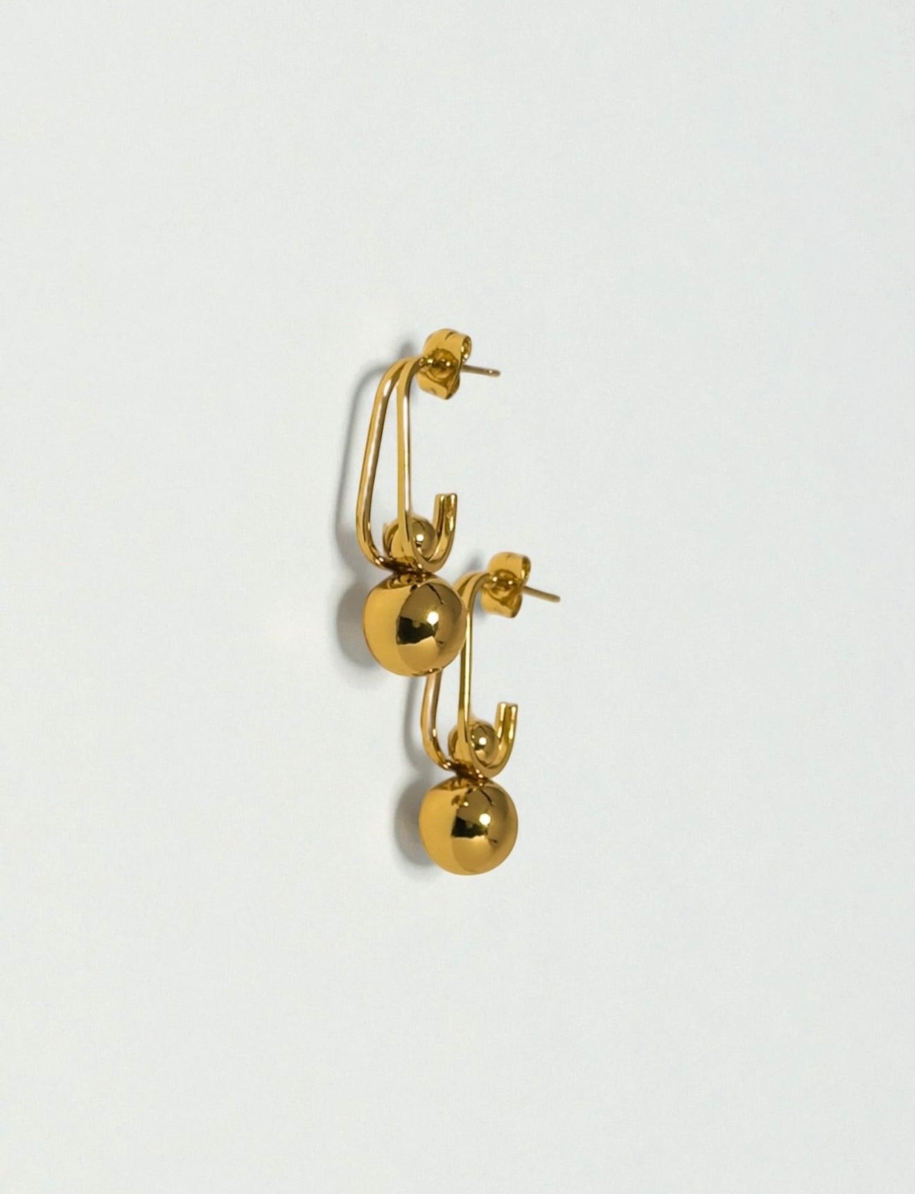 Gold earrings perfect for special occasions, photographed on a off white background