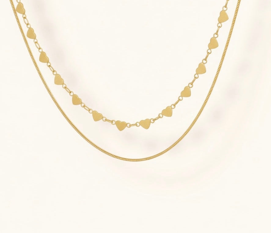 Gold heart-shaped necklace on a white background