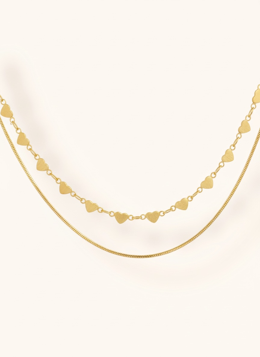 Gold heart-shaped necklace on a white background