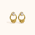 Gold-plated Lunelle Earrings with round circle, bow design, and pearl stud on neutral background