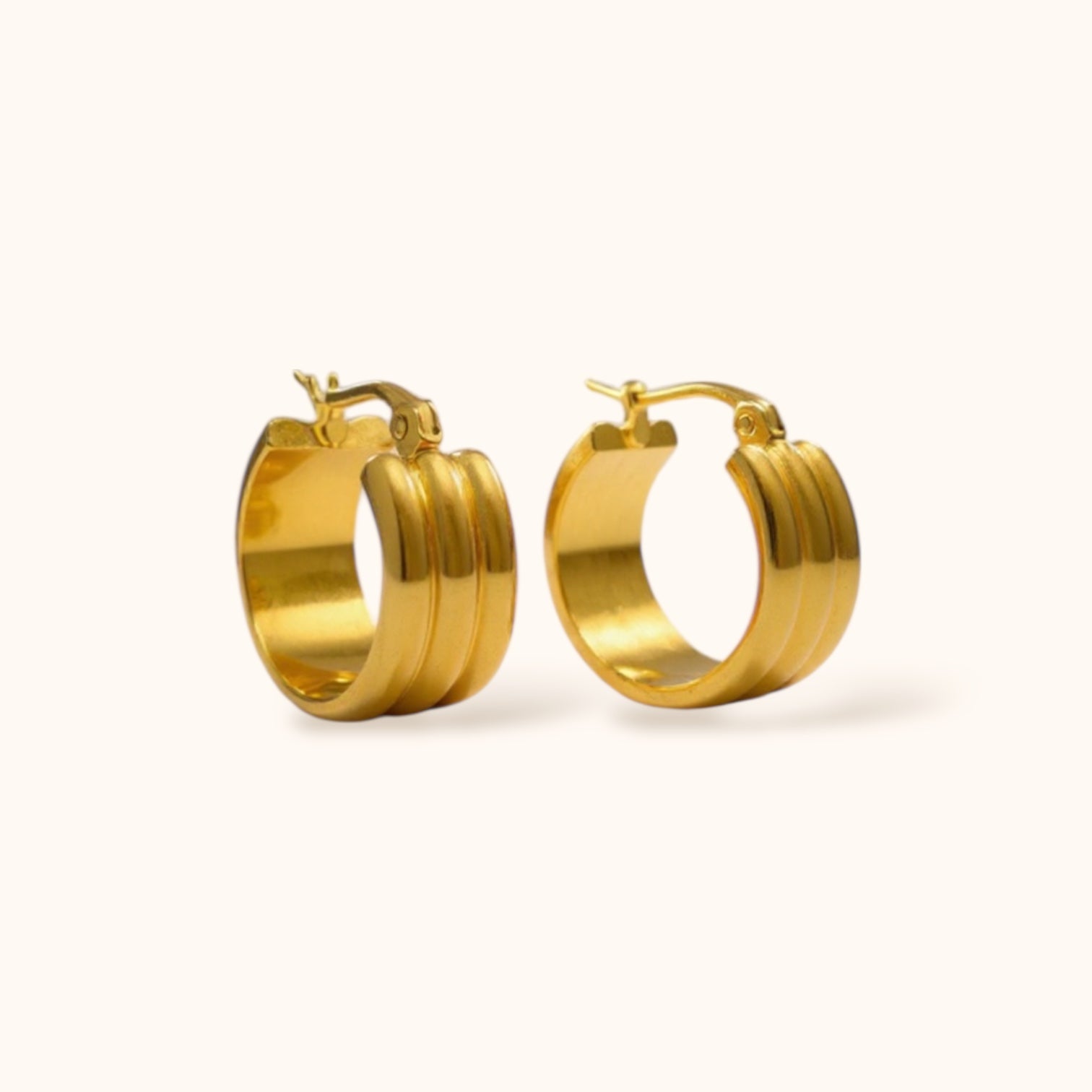 “Gold-plated triple loop hoops on neutral background, minimalist layered earrings for everyday wear”