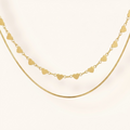 Gold heart-shaped necklace on a light beige background
