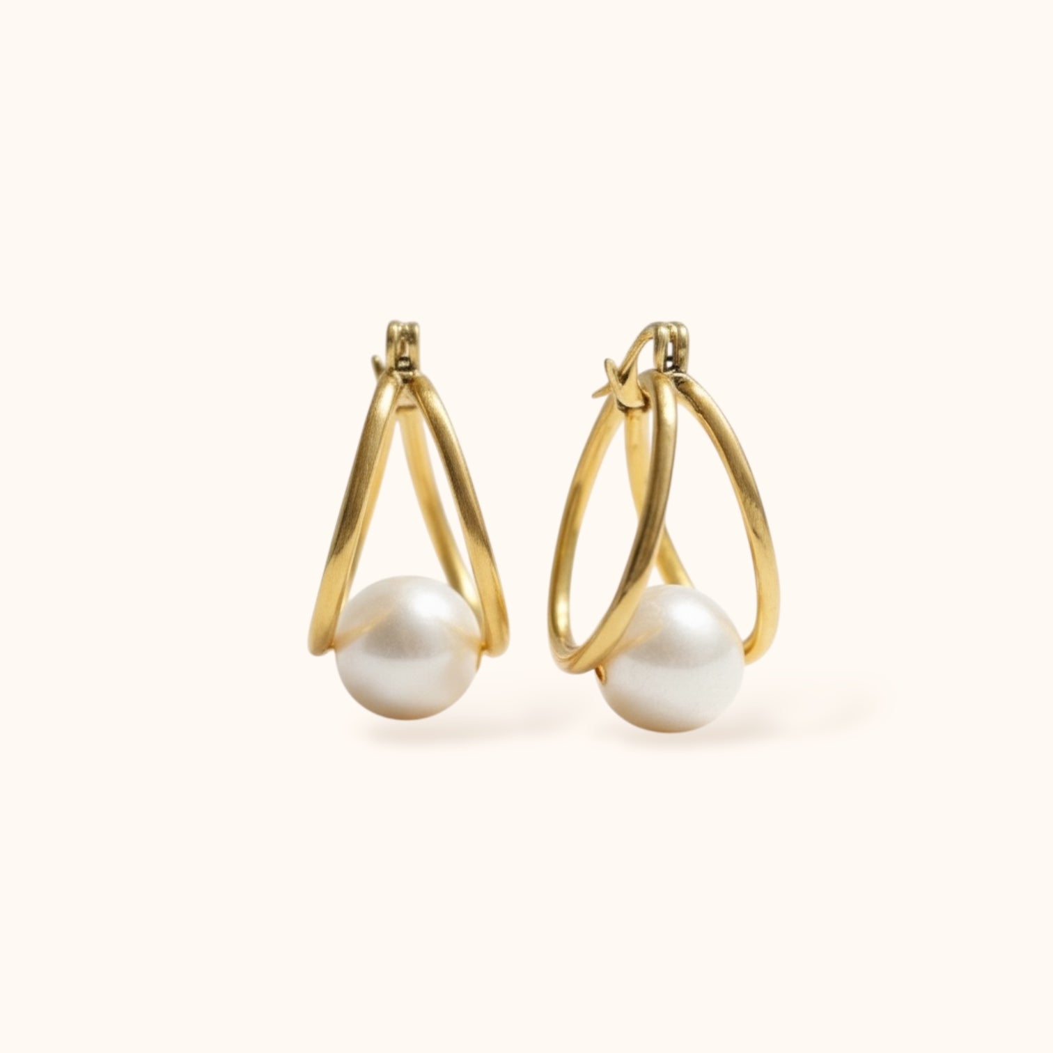 “Modern gold hoop earrings with suspended pearl for layering or solo wear”
