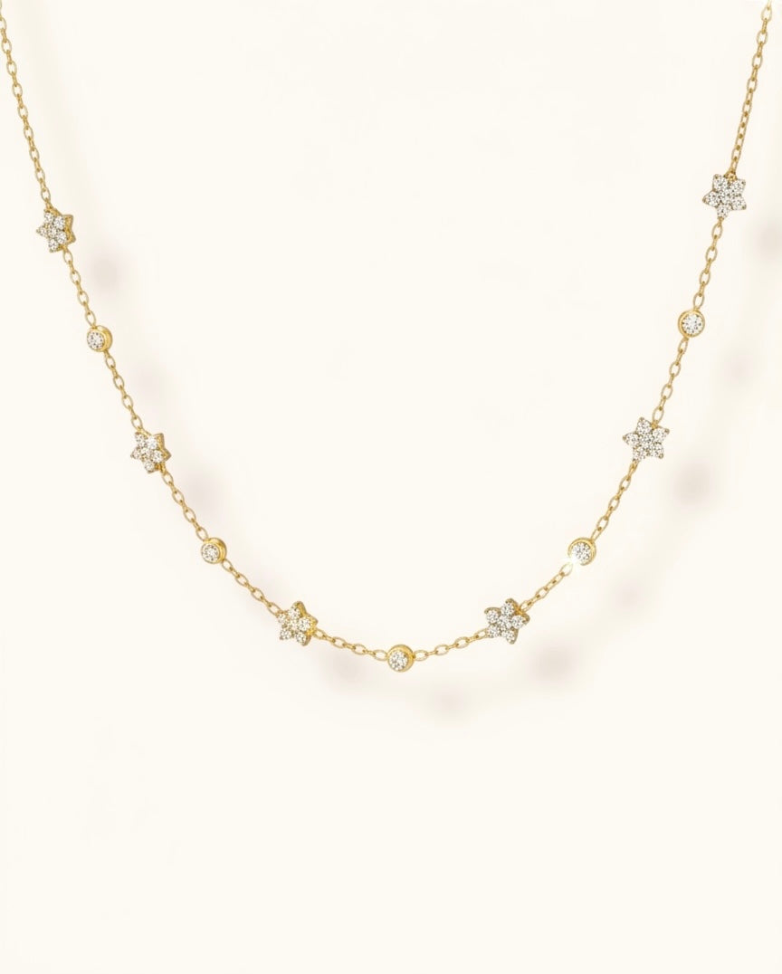 Gold necklace with diamond pendants on a light background